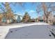Snowy backyard with view of neighboring houses and trees at 950 S Leyden St, Denver, CO 80224