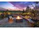 Backyard patio with a stone firepit, seating, water feature, professional landscaping, and stunning sunset at 4213 Hickory Oaks St, Castle Rock, CO 80104