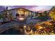 Beautiful backyard featuring a water feature, firepit, patio, covered porch and mature trees, professionally landscaped at 4213 Hickory Oaks St, Castle Rock, CO 80104