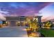 Stunning exterior view of a modern home with a three-car garage, stone accents, and professional landscaping at dusk at 4213 Hickory Oaks St, Castle Rock, CO 80104