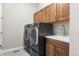 Convenient laundry room featuring modern washer and dryer units, ample cabinet space, and a utility sink at 4213 Hickory Oaks St, Castle Rock, CO 80104