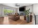 Spacious living room with hardwood floors, a modern fireplace, a large TV, and a wall of windows at 4213 Hickory Oaks St, Castle Rock, CO 80104