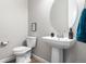 Charming powder room with a pedestal sink, oval mirror, modern fixtures, and stylish decor accents at 4213 Hickory Oaks St, Castle Rock, CO 80104