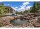 Backyard pond and waterfall feature with lush landscaping and stone accents at 4213 Hickory Oaks St, Castle Rock, CO 80104