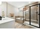 Modern bathroom featuring tub, glass shower with black trim, double vanity and neutral tile at 5417 Riverbend Ave, Firestone, CO 80504