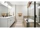 Bright bathroom with double vanity, soaking tub, glass enclosed shower with neutral toned tiles at 5417 Riverbend Ave, Firestone, CO 80504