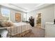 Cozy bedroom with tray ceiling, carpet, poster, and a doorway leading to the bathroom at 5417 Riverbend Ave, Firestone, CO 80504