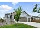 Charming two-story home featuring stone accents, gray siding, a well-manicured lawn, and a spacious three-car garage at 5417 Riverbend Ave, Firestone, CO 80504