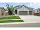 A well-kept home featuring stone accents, gray siding, a manicured lawn, and a convenient three-car garage at 5417 Riverbend Ave, Firestone, CO 80504