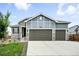 A beautiful house featuring stone accents and a large three car garage, providing both style and convenience at 5417 Riverbend Ave, Firestone, CO 80504