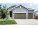 Home with a three-car garage, stone accents, and attractive light gray siding for a great curb appeal at 5417 Riverbend Ave, Firestone, CO 80504