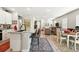 Open floor plan view of kitchen flowing into dining and living spaces with natural light at 5417 Riverbend Ave, Firestone, CO 80504