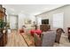 Well-lit living room featuring hardwood floors, a comfortable couch, and stylish decor at 5417 Riverbend Ave, Firestone, CO 80504