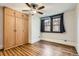 This bedroom has hardwood floors, a ceiling fan, a window with curtains, and built in storage at 740 N Sherman St # 107, Denver, CO 80203