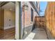 Exterior view showcases brick facade and wooden gate, leading indoors to hardwood floors at 740 N Sherman St # 107, Denver, CO 80203