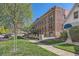 Brick building exterior view showcases the building's architecture with a lush green lawn and sidewalk at 740 N Sherman St # 107, Denver, CO 80203
