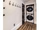 Laundry closet featuring a stacked washer and dryer set, adjacent to wall hooks, and wood flooring at 740 N Sherman St # 107, Denver, CO 80203