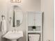 Charming powder room featuring a pedestal sink, oval mirror, and white storage cabinet for added convenience at 3542 W 125Th Dr, Broomfield, CO 80020