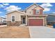 Charming two-story home with stone accents, a two-car garage, and complementary tan and red exterior colors at 20630 E 58Th Ave, Aurora, CO 80019