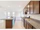 Open concept kitchen featuring a center island with a sink, granite countertops, and stainless steel appliances at 20630 E 58Th Ave, Aurora, CO 80019