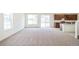 Bright, spacious living area with neutral carpeting, large windows, and a modern kitchen, perfect for entertaining at 20630 E 58Th Ave, Aurora, CO 80019