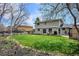 Beautiful backyard with healthy lawn and garden bed, mature trees and rear view of house with patio at 8029 W Hoover Pl, Littleton, CO 80123
