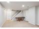Spacious finished basement with neutral carpet, stairs, two doors, and overhead lighting at 8029 W Hoover Pl, Littleton, CO 80123