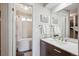 Beautiful bathroom with modern vanity, soaking tub with shower, and stylish light fixture at 8029 W Hoover Pl, Littleton, CO 80123