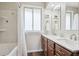 Bathroom with double sink vanity, quartz countertop, and shower-tub combination, with window at 8029 W Hoover Pl, Littleton, CO 80123