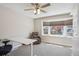 Bright bedroom features an adjustable desk, recliner chair, and large window with neighborhood views at 8029 W Hoover Pl, Littleton, CO 80123