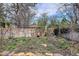 Landscaped garden bed with emerging spring bulbs, wood fencing, and a metal arbor at 8029 W Hoover Pl, Littleton, CO 80123