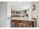 View of the kitchen with a breakfast bar, stainless steel sink, and granite countertops at 8029 W Hoover Pl, Littleton, CO 80123
