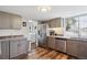 Kitchen with stainless steel appliances, grey cabinetry, hardwood floors, and lots of natural light at 8029 W Hoover Pl, Littleton, CO 80123