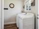 Bright laundry room offers wood-look floors, storage shelf, modern washer and dryer, and a view to the outdoors at 8029 W Hoover Pl, Littleton, CO 80123