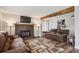 Spacious living room with a fireplace, hardwood floors, and a rustic beam at 8029 W Hoover Pl, Littleton, CO 80123