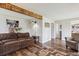 Living room with hardwood floors, rustic beam, and view into the kitchen at 8029 W Hoover Pl, Littleton, CO 80123