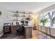 Bright and airy home office featuring a rustic wooden desk, shelving, and ample natural light from a window at 8029 W Hoover Pl, Littleton, CO 80123