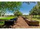 Scenic backyard featuring raised garden beds, mature trees, and a pergola with a patio for outdoor enjoyment at 8184 S Ireland Way, Aurora, CO 80016