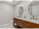 Modern bathroom featuring double vanity with a marble countertop and backsplash, and oval mirrors at 8184 S Ireland Way, Aurora, CO 80016
