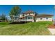 Expansive backyard with lush lawn, mature trees, and an extended pergola-covered deck at 8184 S Ireland Way, Aurora, CO 80016