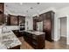 Modern kitchen with a large island, stainless steel appliances, and dark wood cabinetry at 8184 S Ireland Way, Aurora, CO 80016