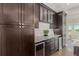 Dark wood cabinets, granite countertops, and wine refrigerators enhance this kitchen's luxurious appeal at 8184 S Ireland Way, Aurora, CO 80016