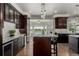 Spacious kitchen with granite countertops, dark cabinetry, stainless steel appliances, and a wine fridge at 8184 S Ireland Way, Aurora, CO 80016