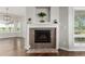 Living room features a fireplace with mosaic tile, hardwood floors, and bright windows at 8184 S Ireland Way, Aurora, CO 80016
