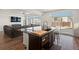 Open-concept kitchen featuring a large island with sink, breakfast bar, and modern appliances at 21901 E 42Nd Place, Aurora, CO 80019