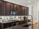 Stylish kitchen featuring ample dark cabinetry, stainless appliances, and granite countertops at 21901 E 42Nd Place, Aurora, CO 80019