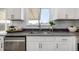 Bright kitchen features white cabinets, stainless steel sink, and gray countertops near a window at 4752 E 108Th Pl, Thornton, CO 80233