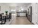 Bright kitchen and dining area featuring white cabinetry, stainless steel appliances, and a sliding glass door to the outside at 4752 E 108Th Pl, Thornton, CO 80233