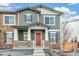 Two-story townhome with gray siding, stone accents, and red door at 20690 E 58Th Ave, Aurora, CO 80019