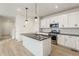 Modern kitchen with white cabinets, granite island, and LVP flooring at 20690 E 58Th Ave, Aurora, CO 80019